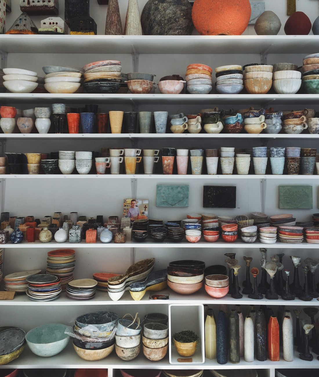 Mugs and bowls packed onto the back room shelves