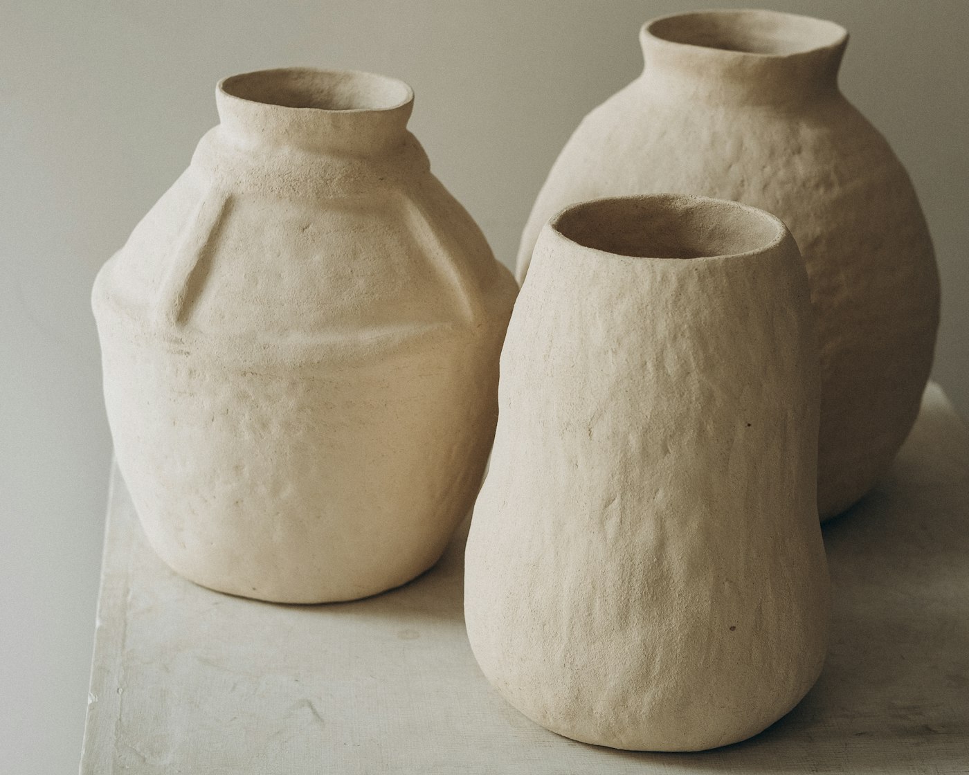 Three Riverbed stoneware vases grouped on a pale surface